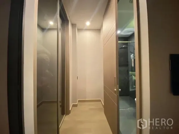 公寓 出租在Huai Khwang, Bangkok - 走廊设镜面衣柜，通向带玻璃淋浴间的现代浴室。