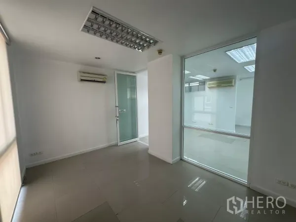 Office Space for rent in Huai Khwang, Bangkok - Private meeting room with a glass door, window blinds and a wall-mounted air conditioner.