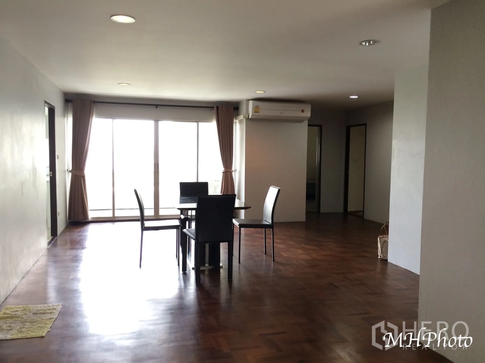Condominium for rent in Watthana, Bangkok - Spacious living and dining area with parquet wood floors, recessed lights and large sliding glass doors to the balcony.