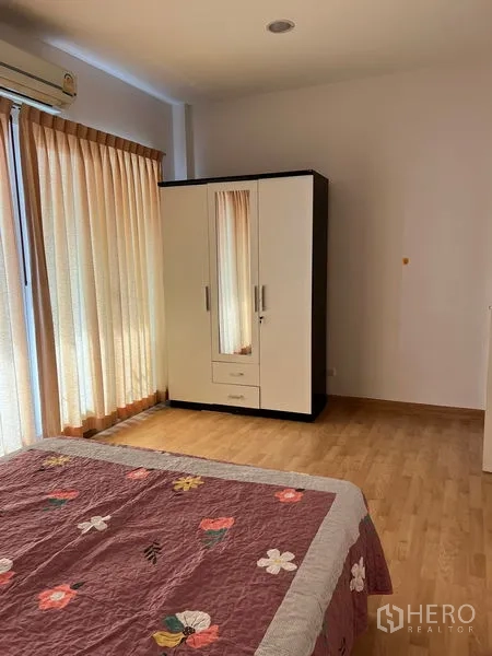 联排别墅 出租在Wang Thonglang, Bangkok - 卧室配床和衣柜，窗帘从顶到地