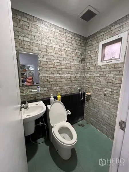 Factory for rent in Lat Lum Kaeo, Pathum Thani - Bathroom with brick-pattern wall tiles, toilet, sink and shower area.