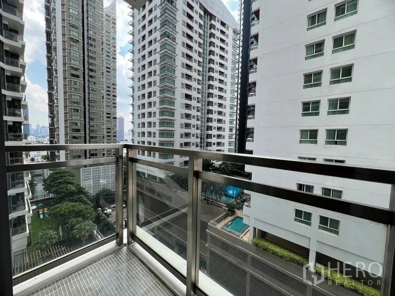 Condominium for rent in Khlong Toei, Bangkok - Corner balcony perspective between towers with views of a landscaped pool area.