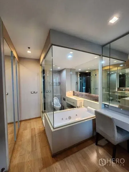 公寓 出售在Ratchathewi, Bangkok - 玻璃墙浴室，配浸泡浴缸、镜面盥洗台与更衣梳妆区，木地板温馨。