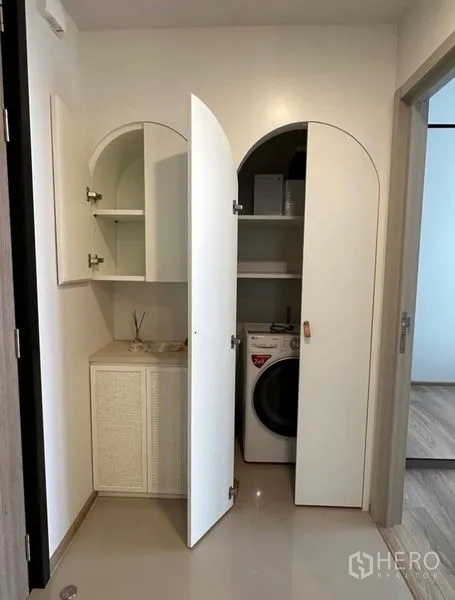 Condominium for rent - Open cabinets revealing shelves and a front-load washer in the condo.