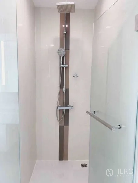 公寓 出租在Watthana, Bangkok - 客厅设沙发与电视，推拉门通往观景阳台。
