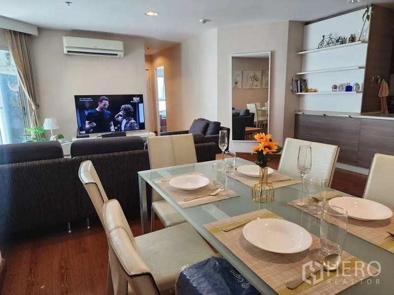 คอนโด ให้เช่าในHuai Khwang, Bangkok - โต๊ะอาหารจัดครบสำหรับหกที่ มองเห็นมุมนั่งเล่นพร้อมทีวีและเครื่องปรับอากาศ