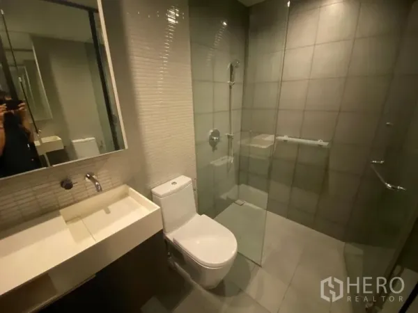 办公空间 出租在Phaya Thai, Bangkok - 浴室配玻璃淋浴间、洗手台与坐便器，灰砖饰面。
