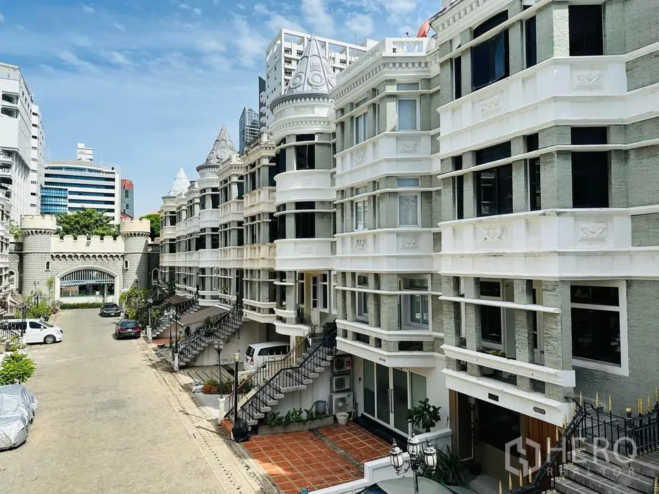 Townhouse for rent - Exterior view of European-style townhouses with front steps and a shared parking courtyard.