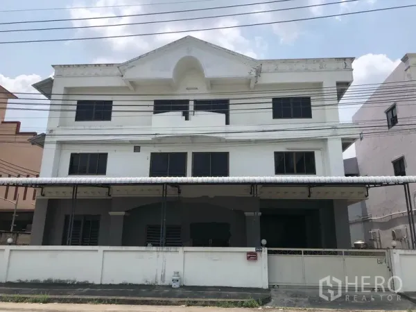 Factory for rent in Bang Bua Thong, Nonthaburi - Front exterior of a three-storey white factory building with gated frontage and metal awning.