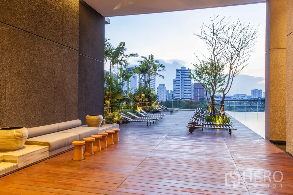 Condominium for rent in Pathum Wan, Bangkok - Shaded outdoor deck with seating, sun loungers and Bangkok skyline views.
