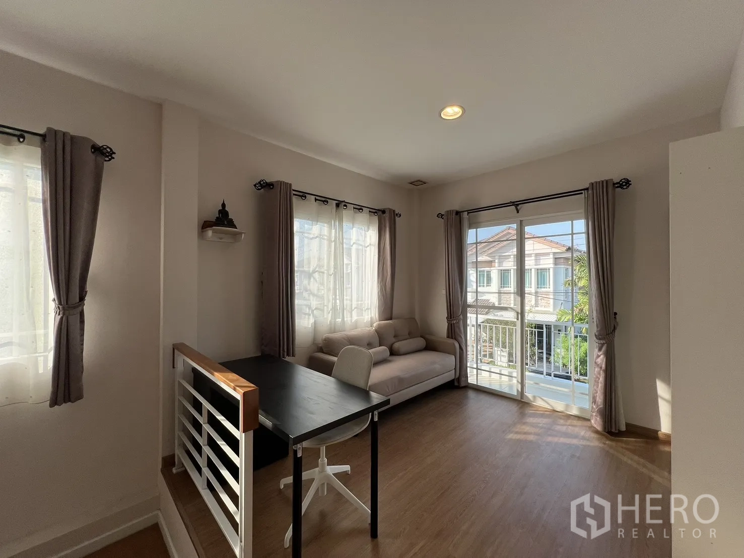 Detached House for rent in Bang Kapi, Bangkok - Upstairs family area with sofa and sliding doors to the balcony.