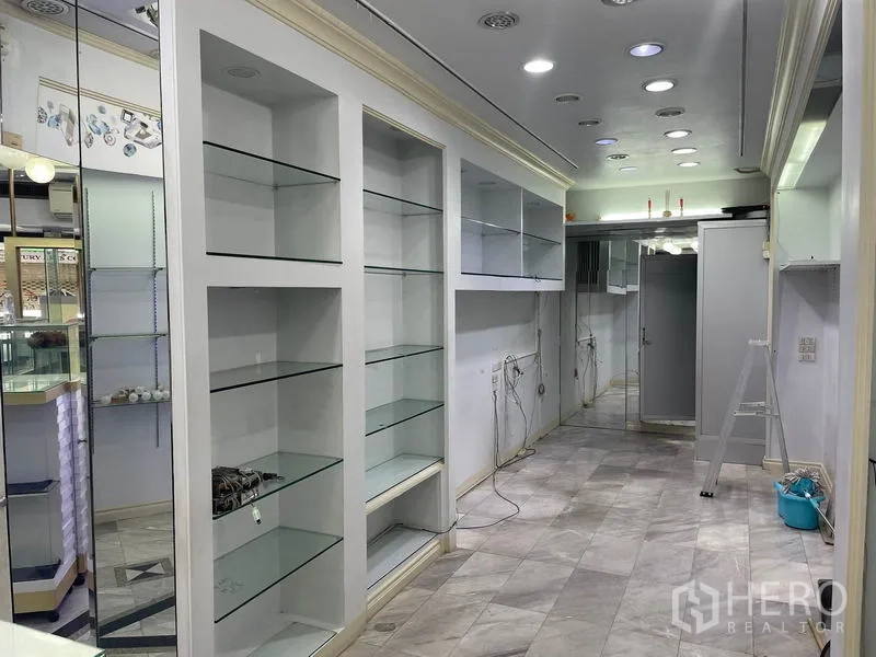 店屋 出租在Bang Rak, Bangkok - 整面镜墙与通长玻璃搁架贯穿全店。