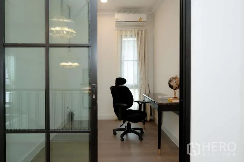 Detached House for rent or sale in Saphan Sung, Bangkok - Compact home office behind framed glass door with desk and ergonomic chair.