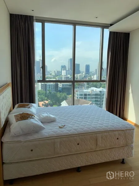 公寓 出租在Watthana, Bangkok - 卧室设大窗与双人床，视野开阔的城市景观。