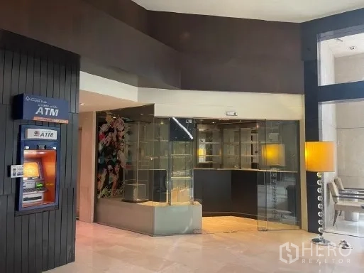 Retail Space for rent in Watthana, Bangkok - Glass-fronted retail unit opening to a bright building lobby with an ATM and seating area.