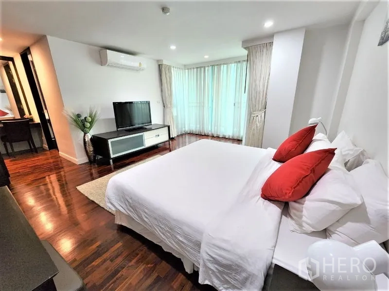 Condominium for rent in Bang Rak, Bangkok - Master bedroom view with TV console, floor-to-ceiling windows, air conditioning and rich wood floors.