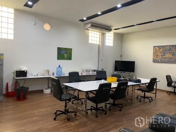 Warehouse for rent in Mueang Samut Prakan, Samut Prakan - Air-conditioned office and meeting room with desks, chairs and wood flooring inside the warehouse.