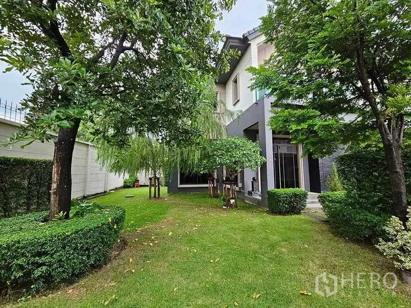 Detached House for sale in Bang Kruai, Nonthaburi - Lush private side garden with lawn, mature trees and trimmed hedges around the house.