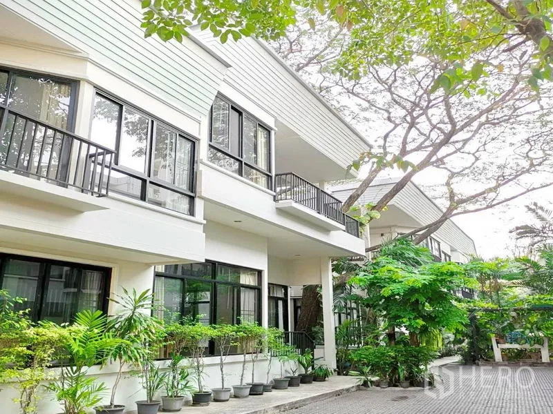 Detached House for rent in Khlong Toei, Bangkok - Contemporary house exterior with large windows, balconies and greenery