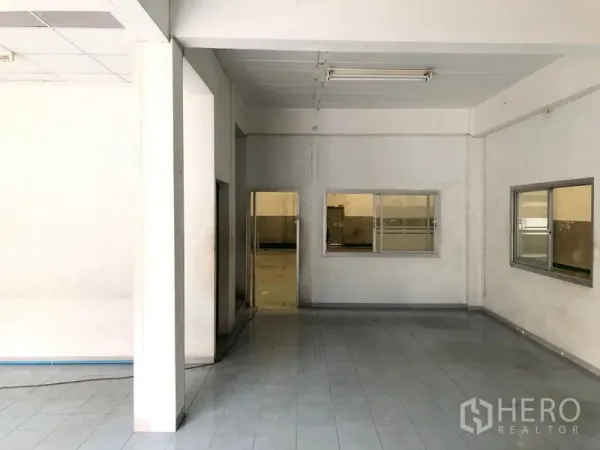 Factory for rent in Pathum Thani - Ground-floor office and reception area with tiled floors, windows and fluorescent lighting inside the factory.
