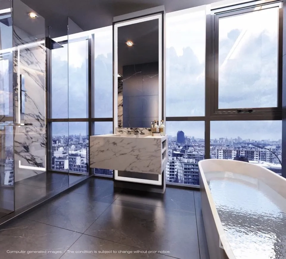 Condominium for sale in Watthana, Bangkok - Marble bathroom with freestanding tub, walk-in rain shower and floor-to-ceiling windows overlooking the Bangkok skyline.