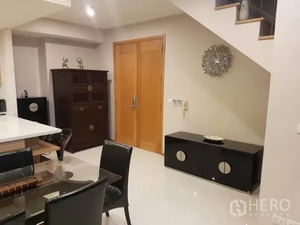 公寓 出租或出售在Khlong Toei, Bangkok - 入口玄关，木门、收纳柜与楼梯的现代公寓。
