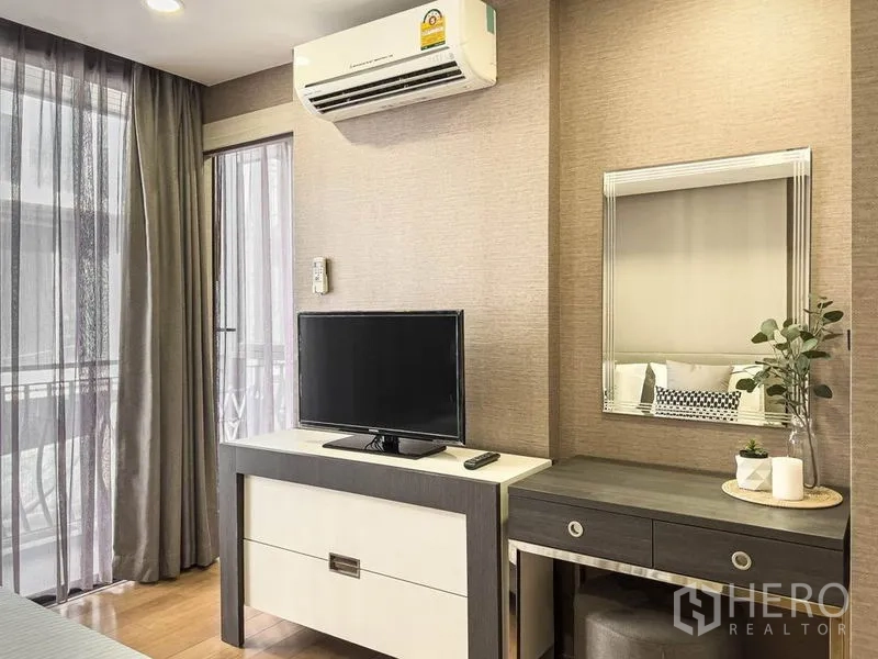 คอนโด ให้เช่าในPathum Wan, Bangkok - มุมห้องนอนพร้อมตู้ทีวี โต๊ะเครื่องแป้ง และผ้าม่านโปร่งเปิดสู่ระเบียง