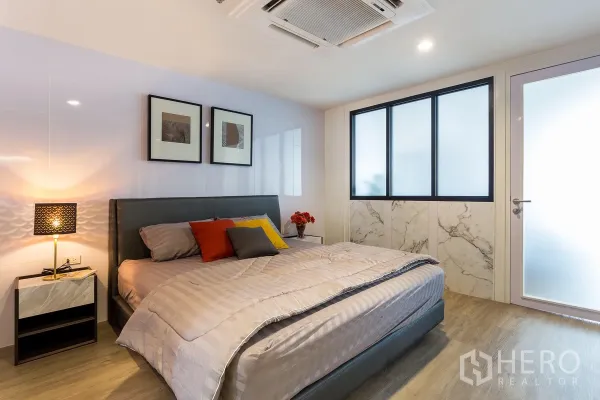 คอนโด ให้เช่าในWatthana, Bangkok - ห้องนอนสว่าง เตียงคิงไซซ์ โคมไฟหัวเตียง และผนังกระจกฝ้าตกแต่งหินอ่อน