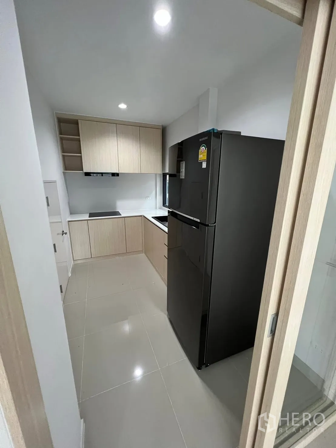 บ้านแฝด for rent in Saphan Sung, Bangkok - ครัวบิลท์อินโทนไม้พร้อมตู้เย็น เตาไฟฟ้า และไฟดาวน์ไลต์
