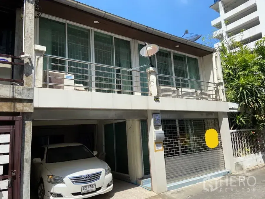 联排别墅 出租在Khlong Toei, Bangkok - 两层联排别墅外观，带阳台、金属护栏与有顶车位，位于素坤逸城市街景。