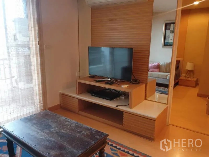 คอนโด ให้เช่าในWatthana, Bangkok - มุมทีวีในห้องนั่งเล่น พร้อมประตูสไลด์เชื่อมห้องนอน และแสงธรรมชาติจากระเบียง