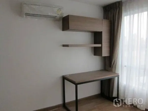 Condominium for rent in Khlong Toei, Bangkok - Compact work-from-home corner featuring a wood desk, floating shelves, and a curtained window.