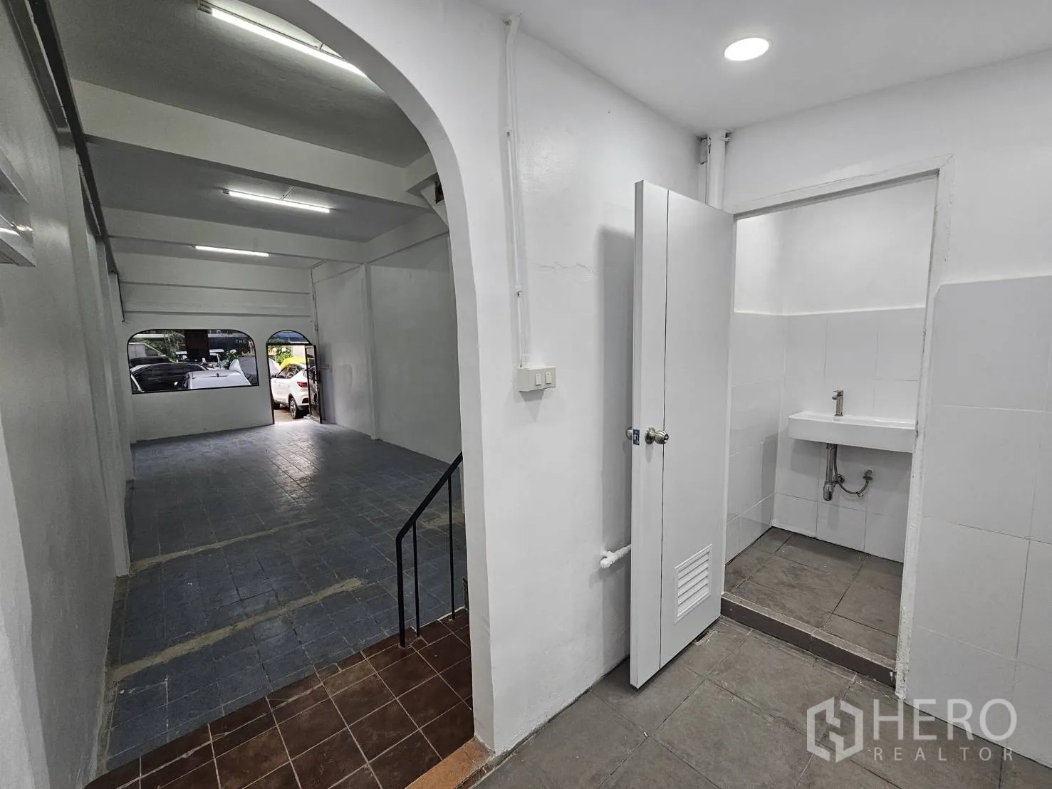 Home Office for rent in Khlong Toei, Bangkok - Entrance to the tiled restroom beside the open workspace on the ground floor.