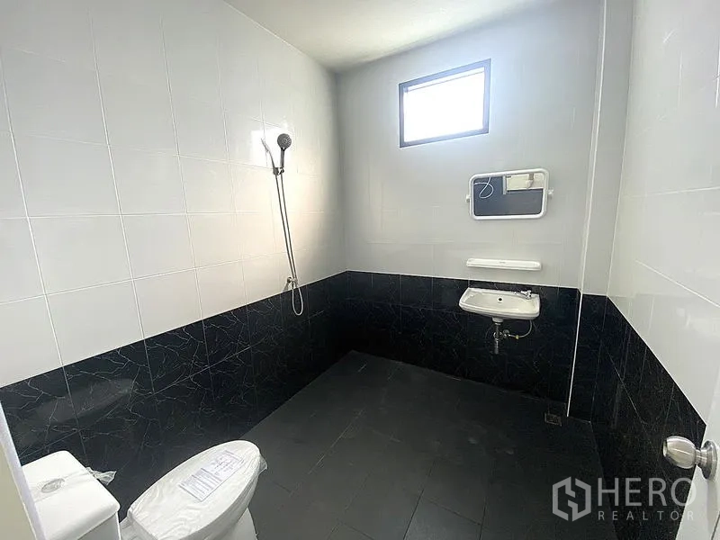 Warehouse for rent in Mueang Pathum Thani, Pathum Thani - Bathroom with black-and-white tiles, shower, toilet and wall-mounted sink.