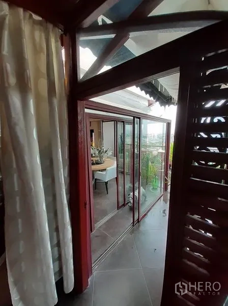 คอนโด ให้เช่าในBang Na, Bangkok - ประตูกระจกบานเลื่อนเชื่อมโซนทานอาหารสู่ระเบียงปลูกต้นไม้