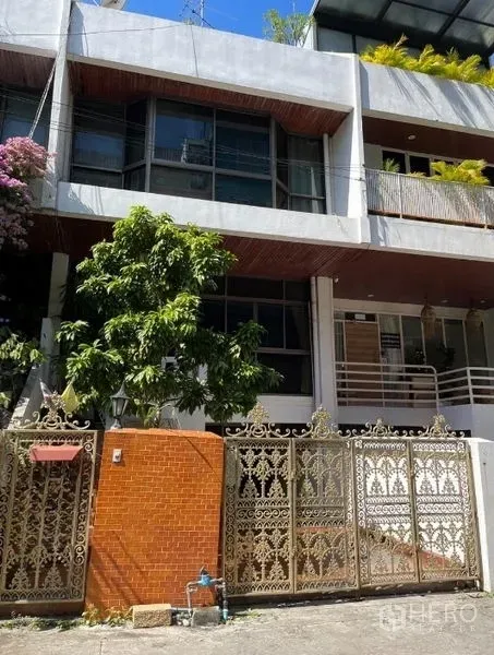 Home Office for rent in Watthana, Bangkok - Modern three-story home office facade with ornate metal gate and a tree in Sukhumvit.