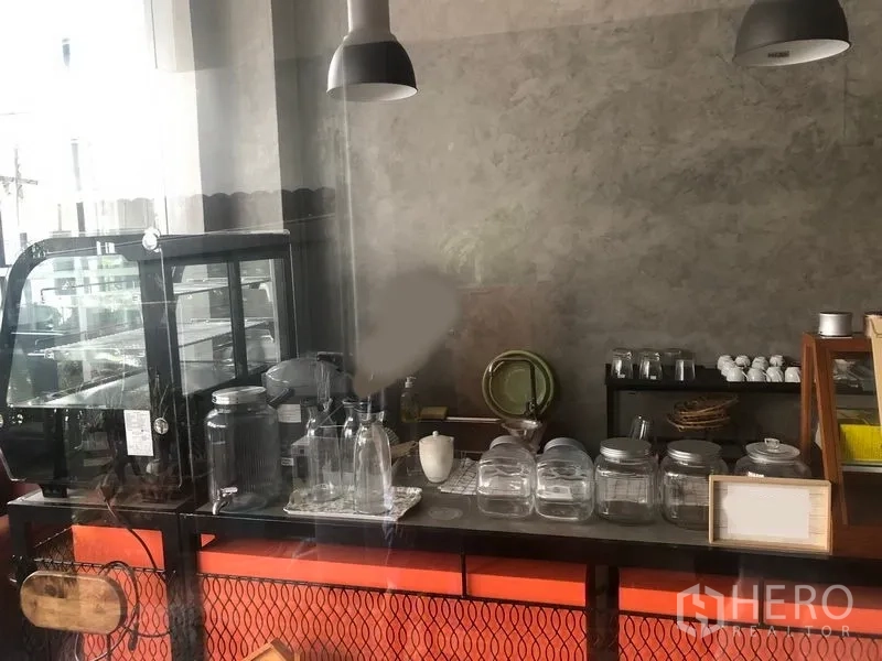 Retail Space for rent in Khlong Toei, Bangkok - Close-up of retail coffee counter with equipment, glass jars and pendant lights.