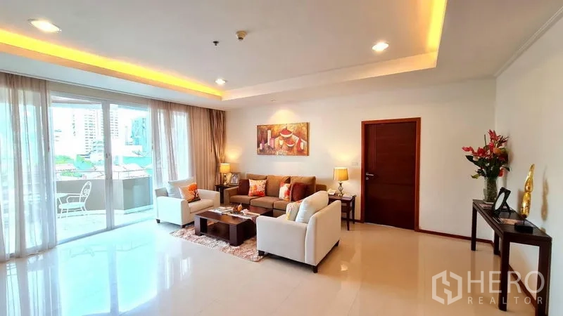 Apartment for rent in Khlong Toei, Bangkok - Bright lounge with sliding glass doors to a balcony in Khlong Toei.