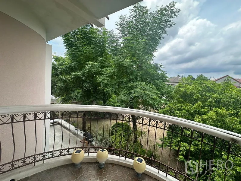 Detached House for sale in Phra Khanong, Bangkok - Curved balcony with wrought-iron railing overlooking mature trees and garden.