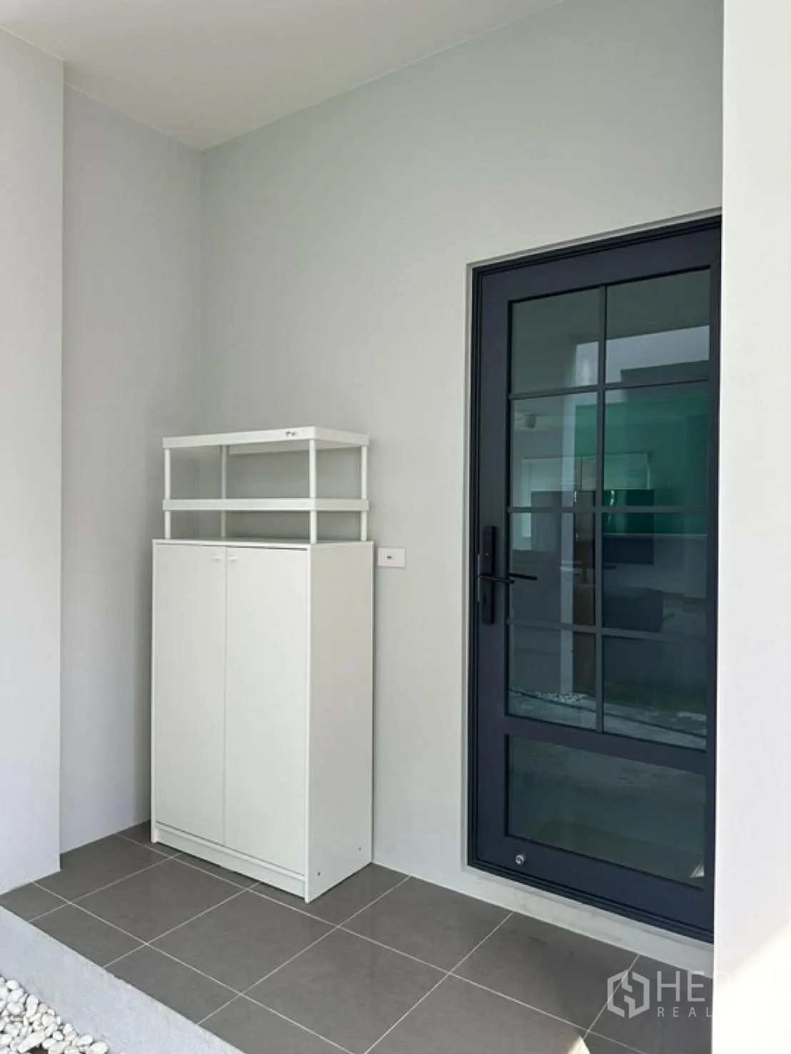 独栋房屋 for rent in Bang Phli, Samut Prakan - 侧边有顶小门廊，深色框玻璃门与鞋柜。