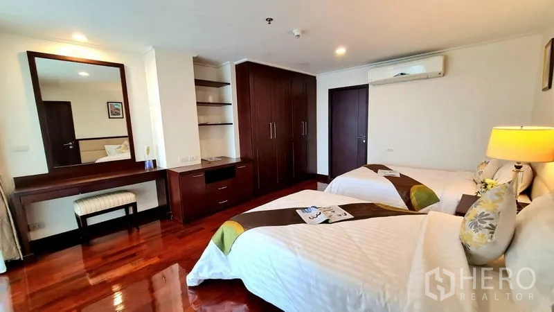 Apartment for rent in Watthana, Bangkok - Twin bedroom with built-in wardrobes, vanity and shelving.