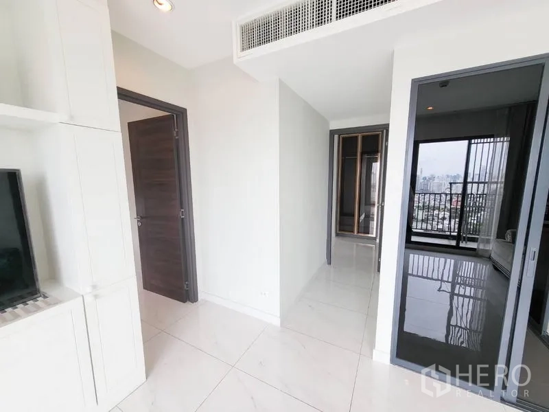 公寓 出售在Watthana, Bangkok - 走廊连接各房与阳台，深色木门与吊顶出风口