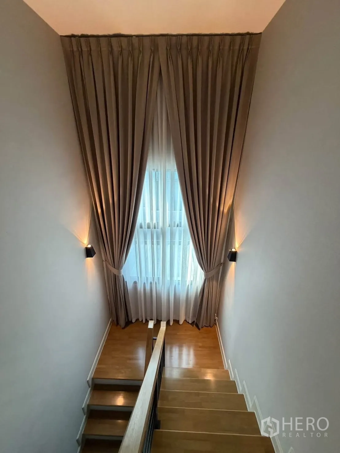 独栋房屋 for rent in Bang Phli, Samut Prakan - 木质楼梯与高挑窗帘，引入自然光。