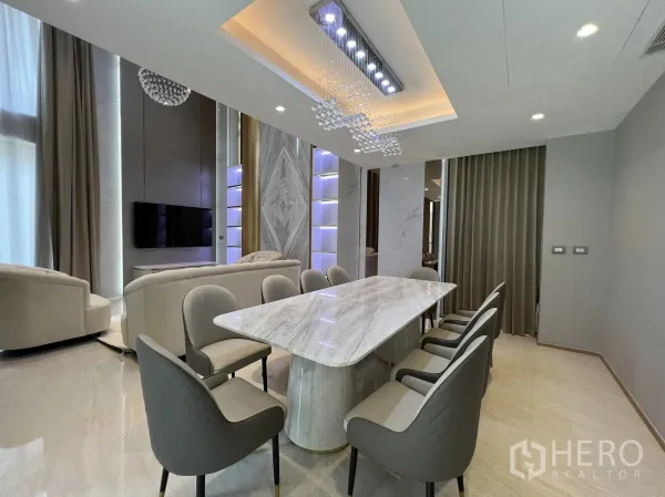 Detached House for rent or sale in Yan Nawa, Bangkok - Open-plan dining space facing the lounge and TV wall with tall curtains.