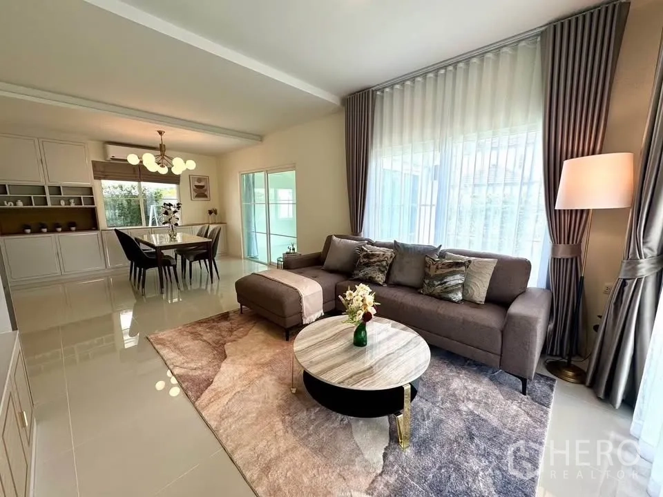 Detached House for rent in Bang Phli, Samut Prakan - Open-plan living and dining room with sectional sofa and sheer curtains.