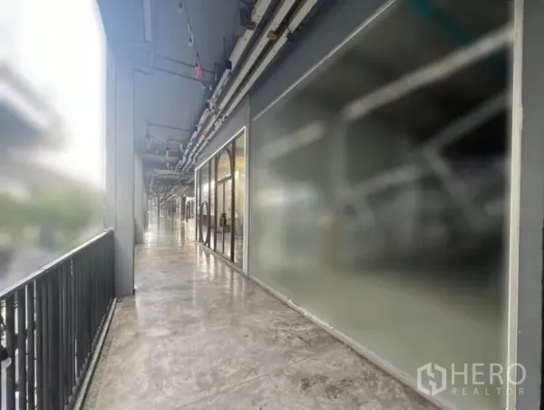 Retail Space for rent in Khlong Toei, Bangkok - Covered outdoor arcade with railings and glass-front retail units along a concrete walkway.