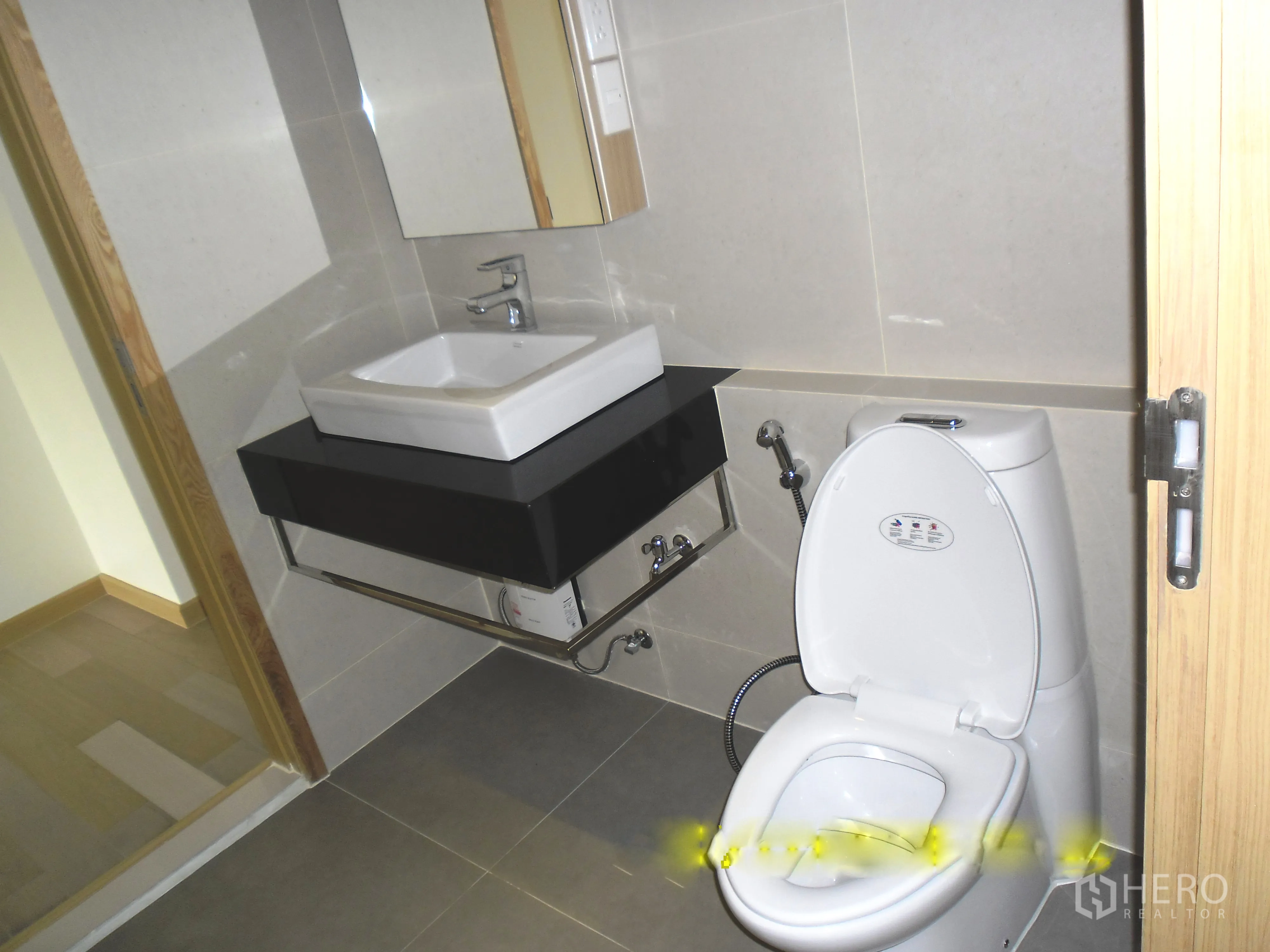 Condominium for rent or sale in Watthana, Bangkok - Clean tiled bathroom with square vanity sink, mirror, and white toilet in a Bangkok condominium.
