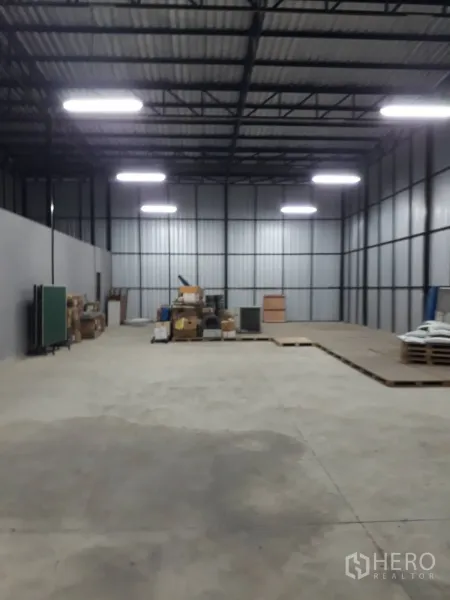 Warehouse for sale in Bang Len, Nakhon Pathom - Warehouse hall illuminated by LED lights showing wide open storage space.