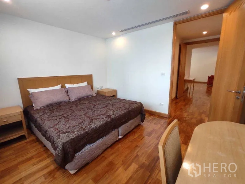 Condominium for rent in Khlong Toei, Bangkok - Master bedroom featuring a king bed, wooden furniture and polished hardwood flooring.