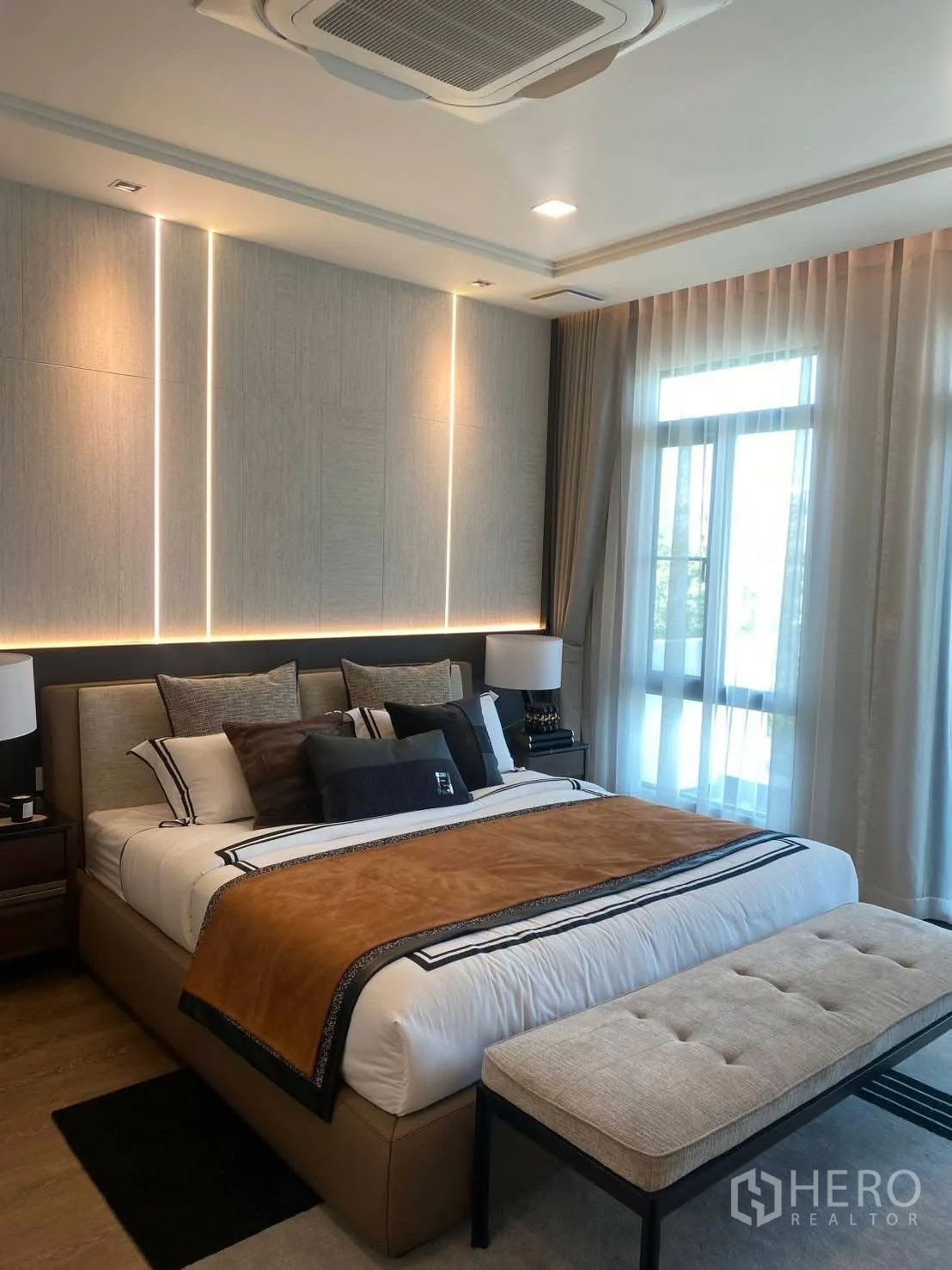 Detached House for rent or sale in Bang Phli, Samut Prakan - Master bedroom with upholstered bed, layered bedding, and soft accent lighting.